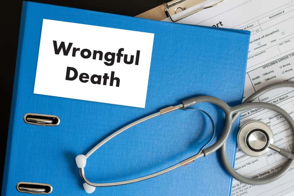 Doctor discusses a wrongful death case with a patient&rsquo;s medical records in hand while working in the office, highlighting medical negligence concerns.