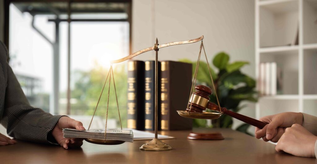 Scales of justice with money and gavel symbolizing legal judgment, settlement, and compensation. Scales of justice with money and gavel symbolizing legal judgment, settlement, and compensation.